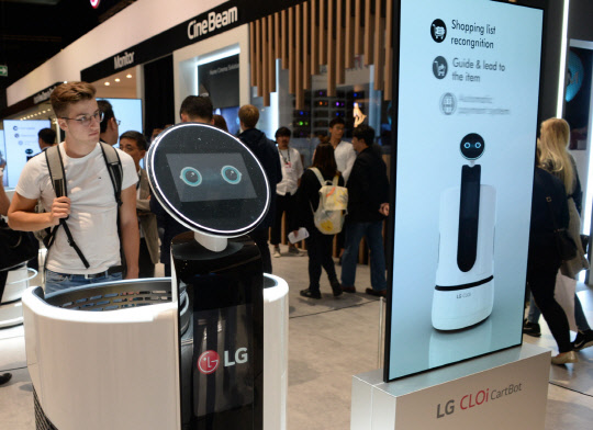 지난 9월 열린 독일 베를린에서 열린 'IFA 2018'에서 관람객이 LG전자의 'LG클로이 카트봇'을 살펴보고 있다. <LG전자>
